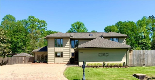 31765 River Pines Dr, Springfield, LA 70462 - traditional home with fence, a front lawn, driveway, and roof with shingles