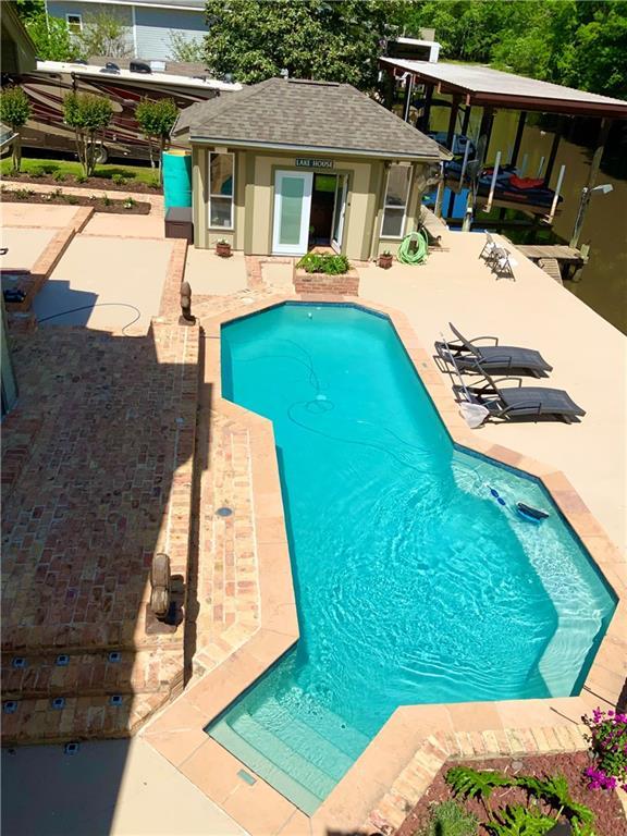 31765 River Pines Dr, Springfield, LA 70462 - outdoor pool featuring an outbuilding, an exterior structure, and a patio