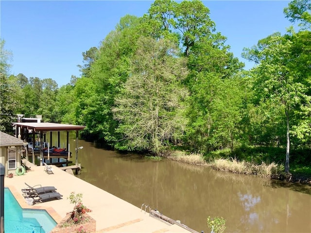 31765 River Pines Dr, Springfield, LA 70462 - dock area with an outdoor pool, a water view, a patio area, and boat lift