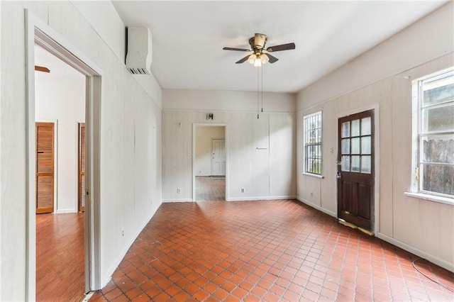unfurnished room with plenty of natural light, a ceiling fan, and baseboards
