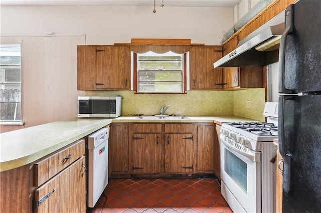 kitchen with exhaust hood, light countertops, a sink, white appliances, and decorative backsplash