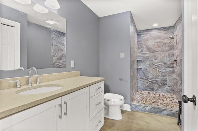 full bathroom with recessed lighting, vanity, toilet, and tiled shower
