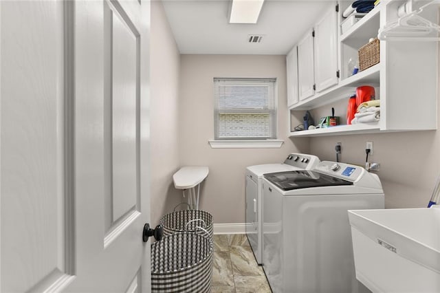 clothes washing area with a sink, baseboards, marble finish floor, independent washer and dryer, and cabinet space
