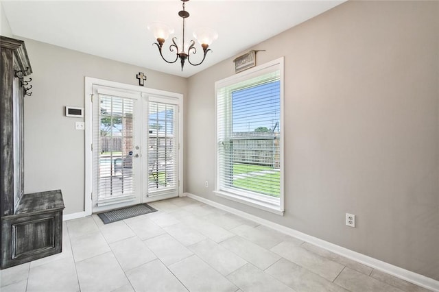 unfurnished dining area with light tile patterned floors, french doors, a chandelier, and baseboards