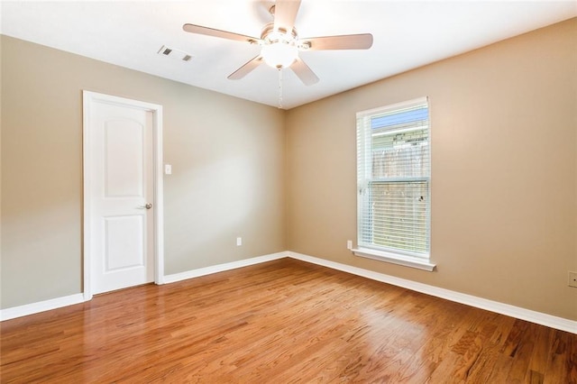 spare room with visible vents, ceiling fan, light wood-style flooring, and baseboards