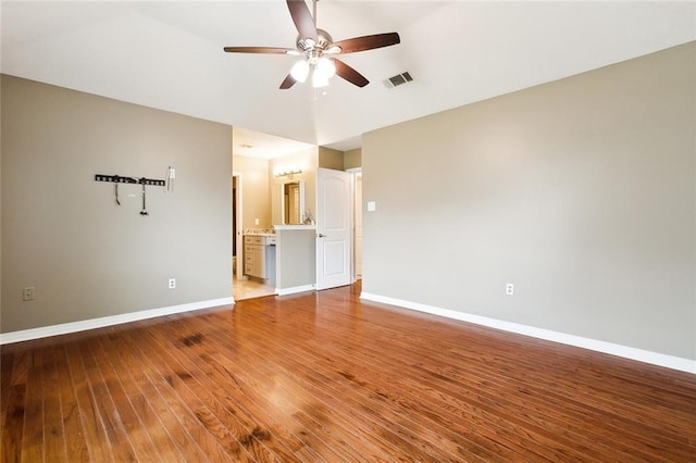 unfurnished room with baseboards, visible vents, hardwood / wood-style flooring, and a ceiling fan