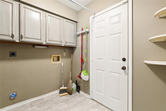 clothes washing area with hookup for an electric dryer, cabinet space, light tile patterned floors, hookup for a washing machine, and baseboards