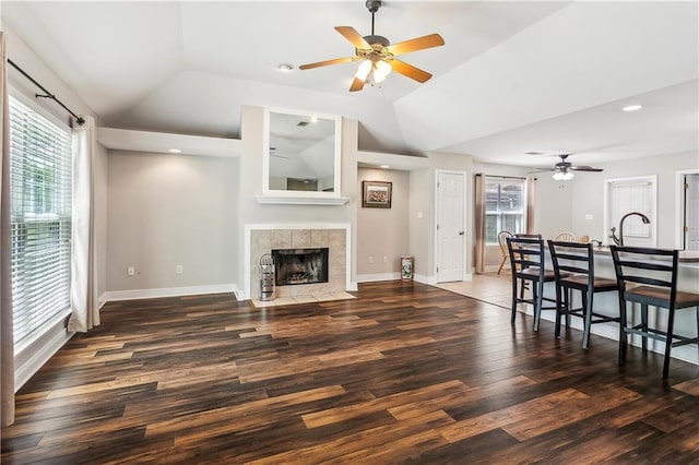 living room featuring lofted ceiling, plenty of natural light, a ceiling fan, and wood finished floors