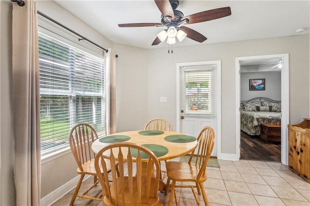 dining space featuring a ceiling fan, baseboards, and light tile patterned flooring