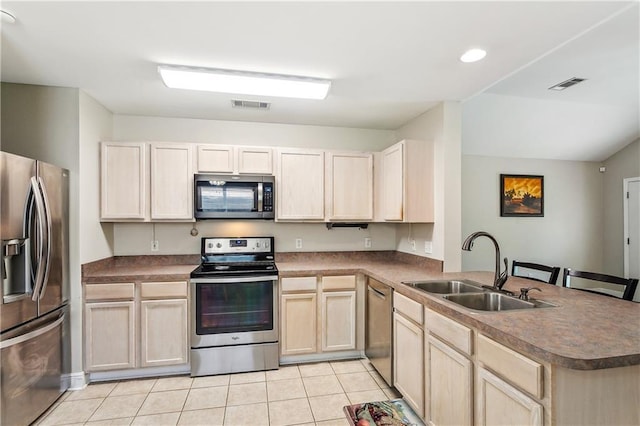 kitchen featuring a peninsula, visible vents, stainless steel appliances, and a sink