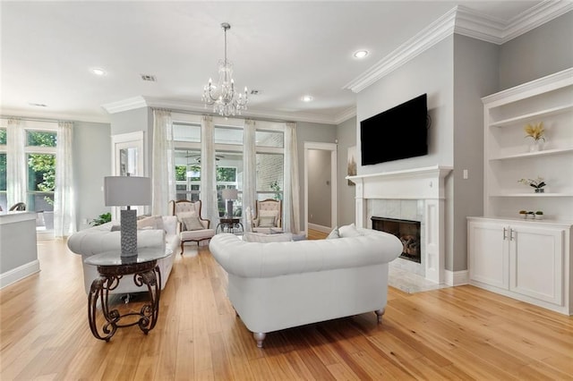 living room featuring light wood-style floors, ornamental molding, and a high end fireplace
