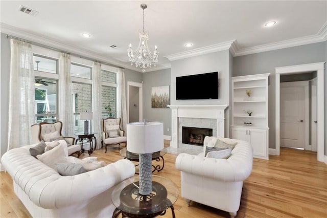 living area featuring light wood-style flooring and crown molding