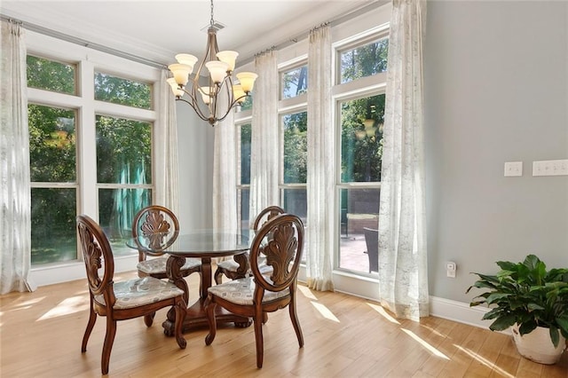 dining space with light wood finished floors, baseboards, a chandelier, and visible vents