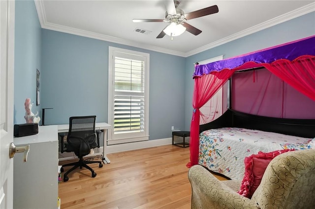 bedroom with wood finished floors, visible vents, crown molding, and baseboards