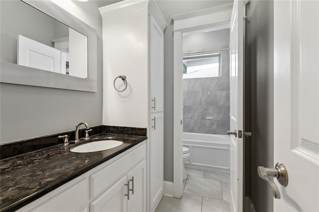 bathroom featuring marble finish floor, toilet, vanity, and bathing tub / shower combination