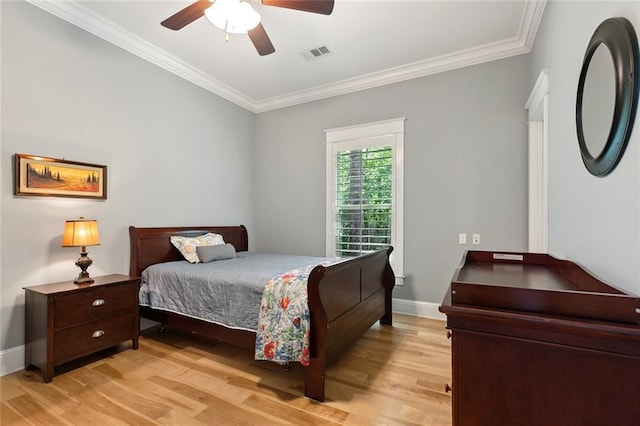 bedroom with baseboards, crown molding, visible vents, and light wood-type flooring