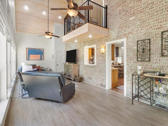 31035 Horseshoe Island Rd, Lacombe, LA 70445 - living room with brick wall, a ceiling fan, wood finished floors, and high vaulted ceiling