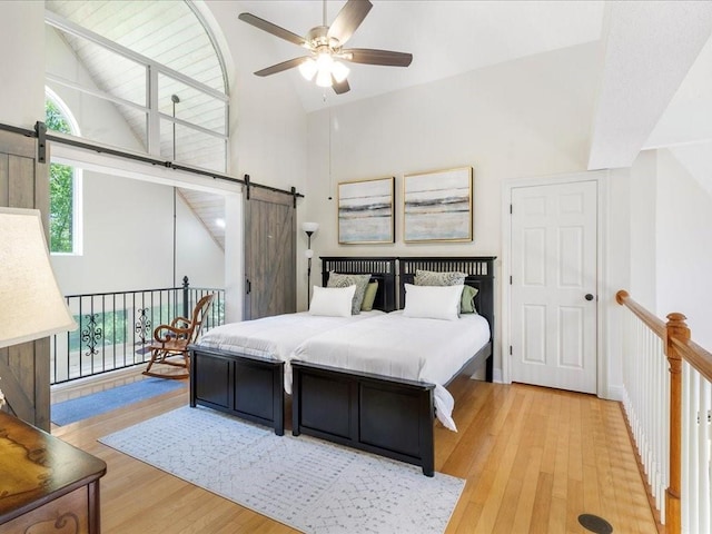 31035 Horseshoe Island Rd, Lacombe, LA 70445 - bedroom featuring light wood-style flooring, a barn door, access to outside, ceiling fan, and high vaulted ceiling
