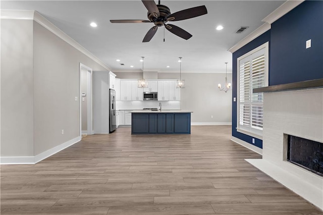 72421 Homestead St, Covington, LA 70435 - unfurnished living room with baseboards, visible vents, light wood-style floors, ceiling fan with notable chandelier, and crown molding