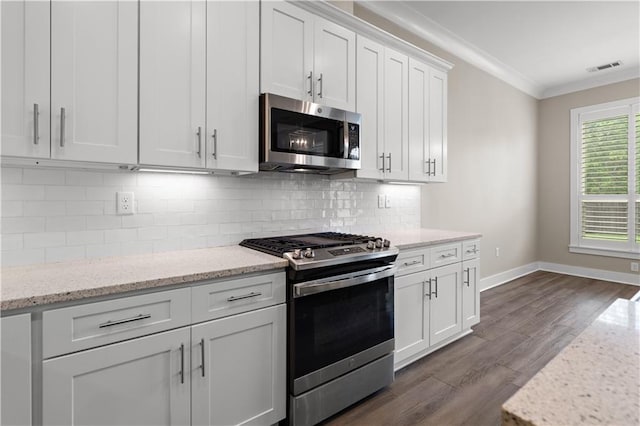 72421 Homestead St, Covington, LA 70435 - kitchen with crown molding, appliances with stainless steel finishes, white cabinets, baseboards, and dark wood-style flooring