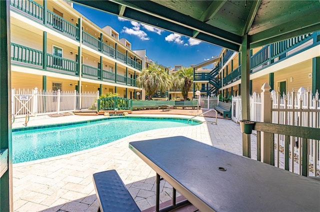 pool with fence and a patio