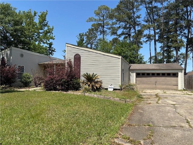 exterior space with concrete driveway, a yard, and a garage