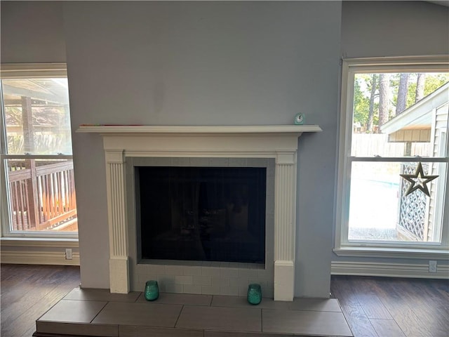 details with wood finished floors and a tiled fireplace