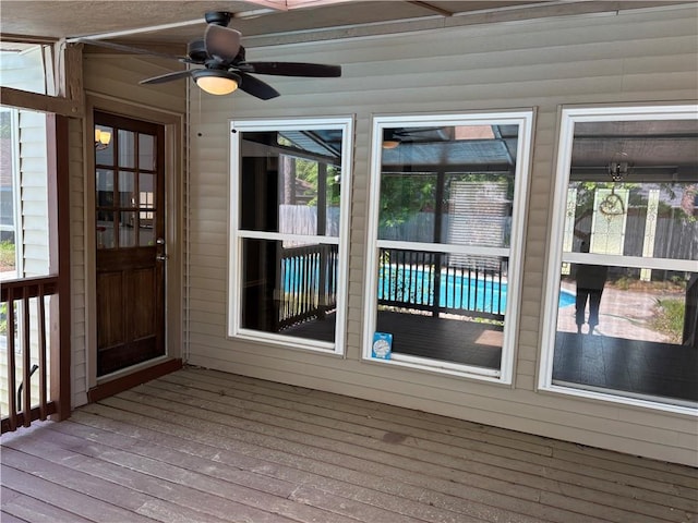 unfurnished sunroom featuring ceiling fan