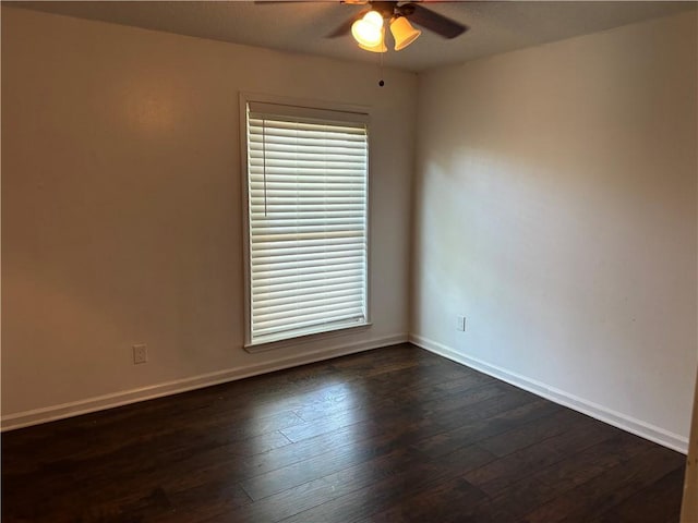 empty room with baseboards, ceiling fan, and dark wood-style flooring