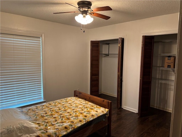bedroom with ceiling fan, dark wood-style flooring, and a textured ceiling