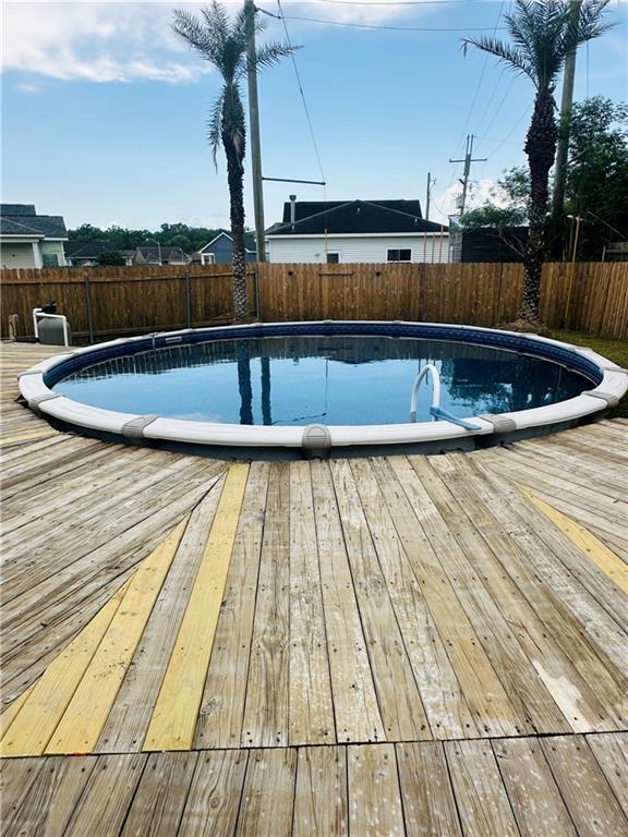view of pool featuring a fenced backyard, a wooden deck, and a fenced in pool