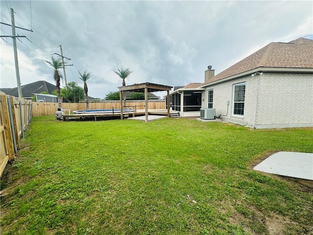 view of yard featuring a gazebo, central air condition unit, a fenced backyard, a fenced in pool, and a sunroom