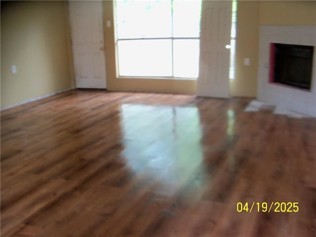 unfurnished living room with wood finished floors and a fireplace