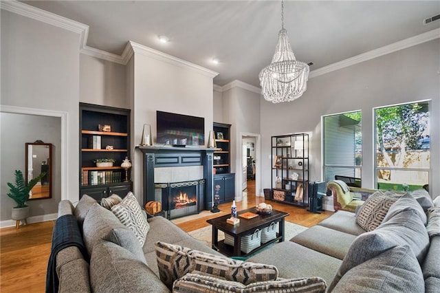 2436 Cours Carson St, Mandeville, LA 70448 - living area with a chandelier, a tile fireplace, wood finished floors, crown molding, and a towering ceiling