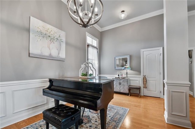2436 Cours Carson St, Mandeville, LA 70448 - sitting room with a chandelier, ornamental molding, a wainscoted wall, light wood-style flooring, and a decorative wall