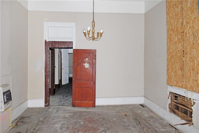 unfurnished dining area featuring an inviting chandelier and baseboards