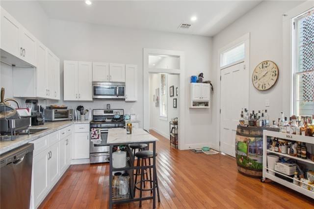 264545 Saint Ann St, New Orleans, LA 70119 - kitchen featuring white cabinets, appliances with stainless steel finishes, hardwood / wood-style floors, and visible vents