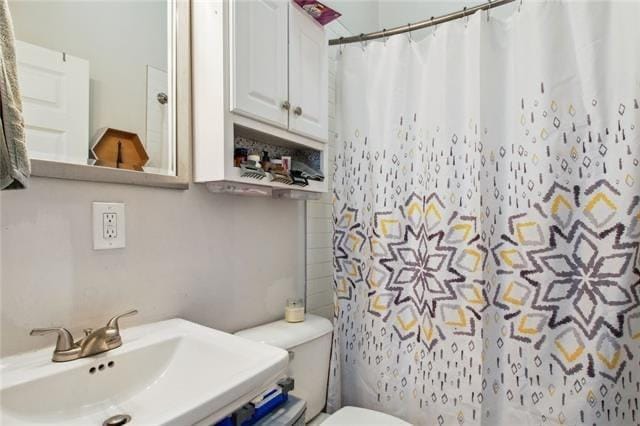 264545 Saint Ann St, New Orleans, LA 70119 - bathroom featuring a shower with shower curtain, toilet, and a sink
