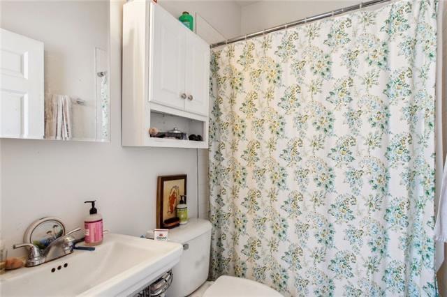 264545 Saint Ann St, New Orleans, LA 70119 - full bathroom featuring curtained shower, toilet, and a sink