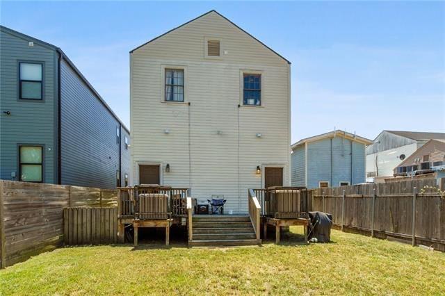 264545 Saint Ann St, New Orleans, LA 70119 - back of property featuring a fenced backyard, a wooden deck, and a lawn