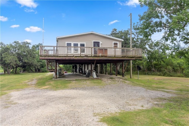 4967A Jean Lafitte Blvd, Lafitte, LA 70067 - view of front of house featuring a carport, a wooden deck, dirt driveway, stairs, and a front lawn