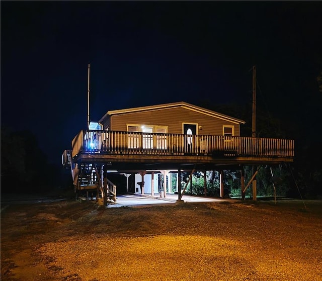4967A Jean Lafitte Blvd, Lafitte, LA 70067 - back of house at night featuring a wooden deck, stairs, and a carport
