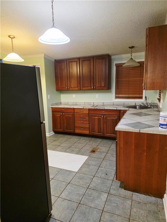 4967A Jean Lafitte Blvd, Lafitte, LA 70067 - kitchen featuring freestanding refrigerator, tile counters, light tile patterned floors, a textured ceiling, and pendant lighting