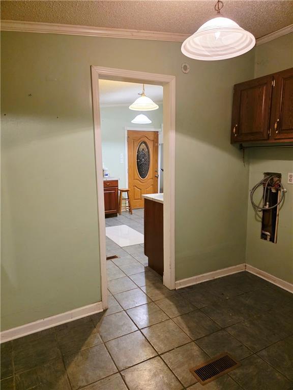 4967A Jean Lafitte Blvd, Lafitte, LA 70067 - corridor featuring tile patterned flooring, a textured ceiling, baseboards, and crown molding