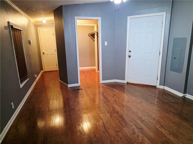 4967A Jean Lafitte Blvd, Lafitte, LA 70067 - unfurnished bedroom featuring electric panel, dark wood-type flooring, a spacious closet, baseboards, and crown molding