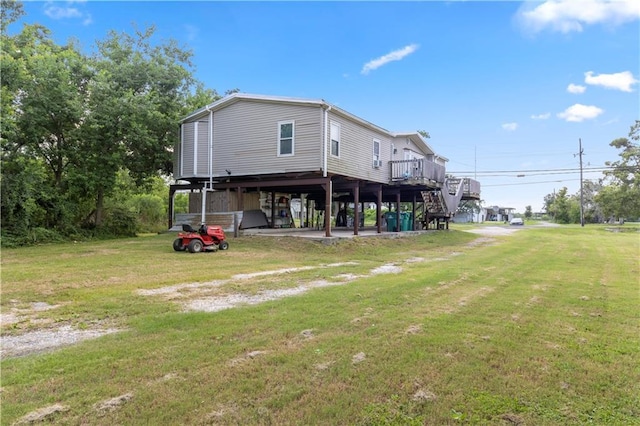 4967A Jean Lafitte Blvd, Lafitte, LA 70067 - back of house with a lawn, a deck, stairway, and a carport