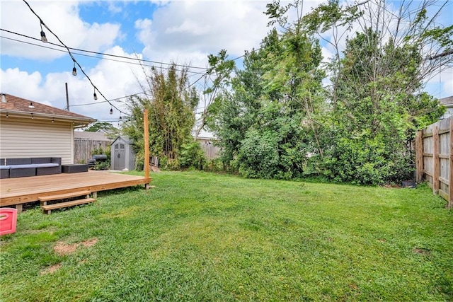view of yard featuring a storage shed, a wooden deck, and an outdoor structure