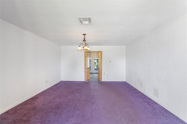 429 Bertolino Dr, Kenner, LA 70065 - spare room with dark colored carpet, visible vents, a textured ceiling, and a notable chandelier