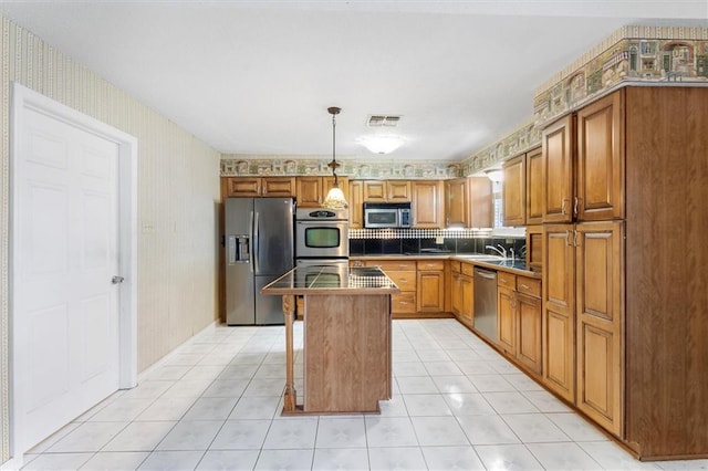 429 Bertolino Dr, Kenner, LA 70065 - kitchen with wallpapered walls, light tile patterned floors, stainless steel appliances, visible vents, and a kitchen island