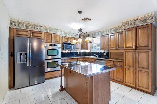 429 Bertolino Dr, Kenner, LA 70065 - kitchen with brown cabinetry, stainless steel appliances, visible vents, and a kitchen island